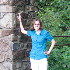 Photo of Kirsten Canfield with the stone arch at the entrance to Dr. McCleery's wolf park